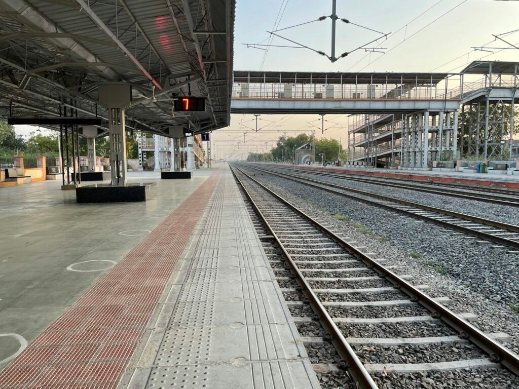 An Indian railway station platform with a train on the tracks