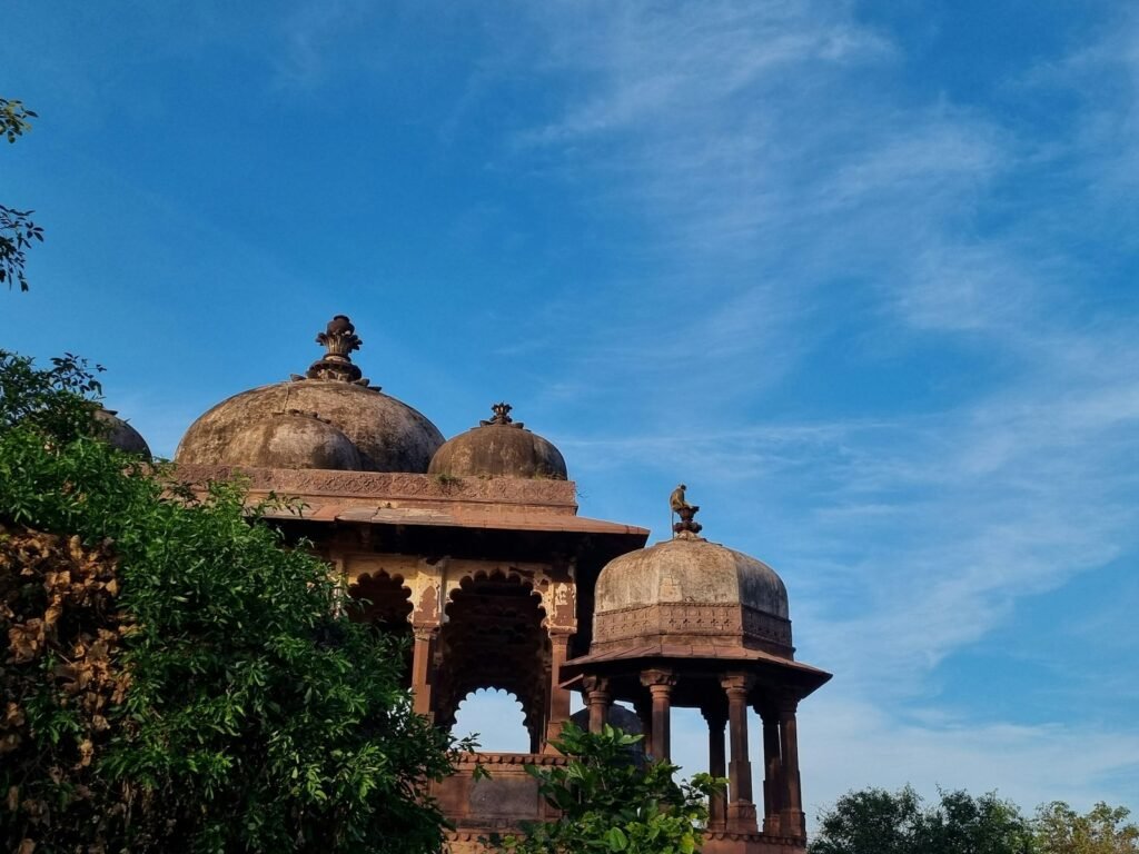 Domed sandstone chhatris against a blue sky