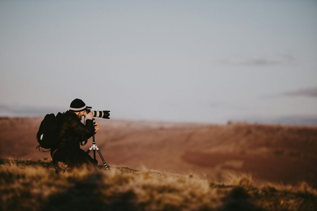 A photographer looking through a camera with a long lens