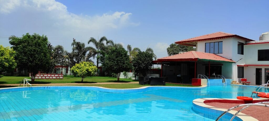 A hotel swimming pool surrounded by green trees
